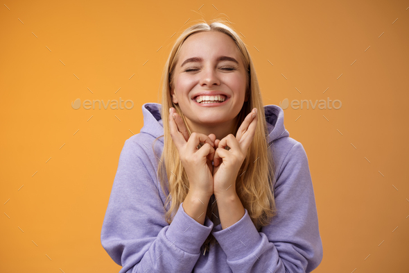 Charming lucky cute young happy hopeful blond girl close eyes smiling positive cross fingers good