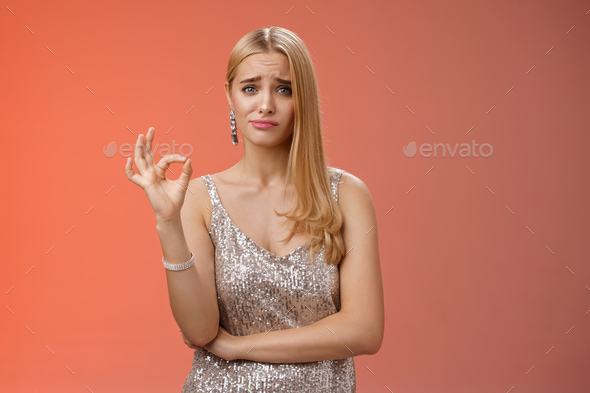 Well not bad. Hesitant unsure cute stylish wealthy blond girlfriend in silver dress frowning