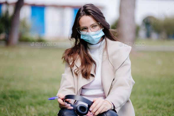 young woman student virtual learning on mobile wearing medical mask new normal