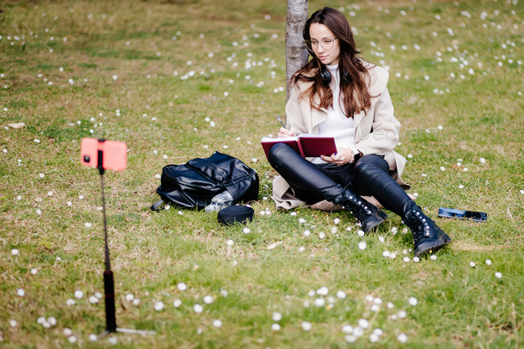 young female virtual learning online courses on smartphone internet outdoors