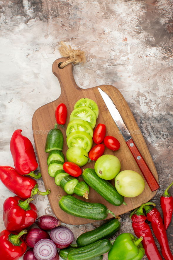 Fresh vegetables on woden cutting board with knife