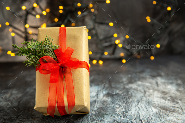 top view small gifts tied with red ribbon xmas tree branch on dark red  table Stock Photo by ImgSolut