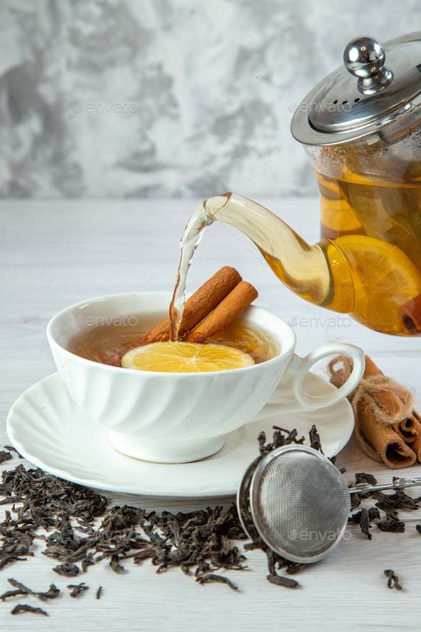 teapot pouring tea into flying cups, on white background Stock