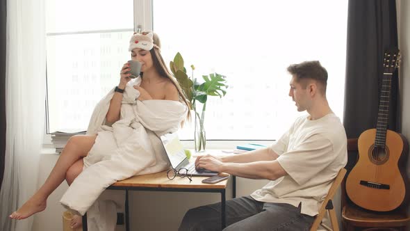 Wife Coquette Only in Blanket Sit on Desk Next To Working Husband alt