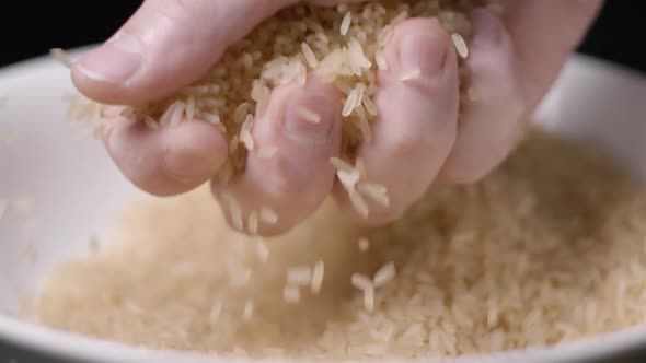 Rice falling in hand slow motion