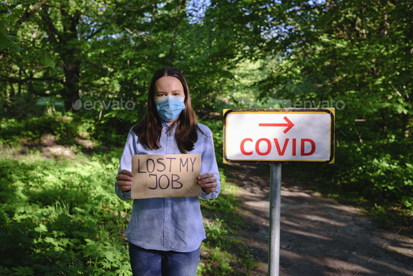 Woman in face mask with cardboard sign LOST JOB