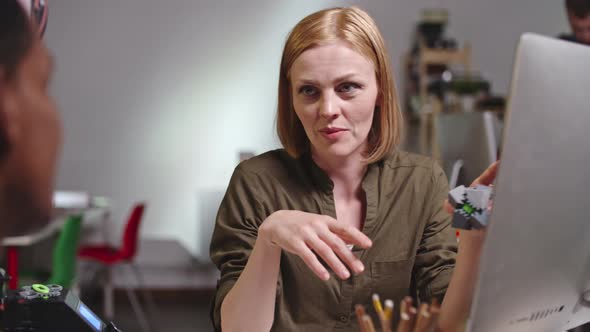 Female Executive Discussing Prototype of Puzzle with Colleague alt