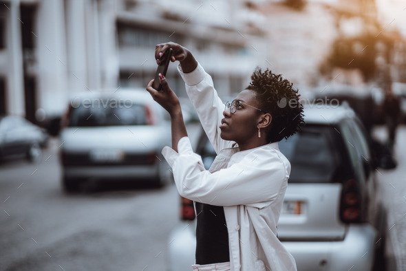 Black girl is taking pics outdoors - Stock Photo - Images