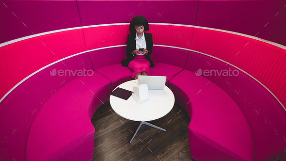 Businesswoman on a pink bent sofa - Stock Photo - Images