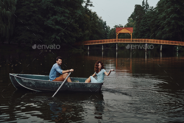 Enjoying great weekend. Beautiful young couple relaxing while enjoying romantic date on the lake