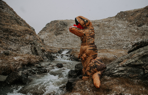 Man With dinosaur costume in a wild natural area