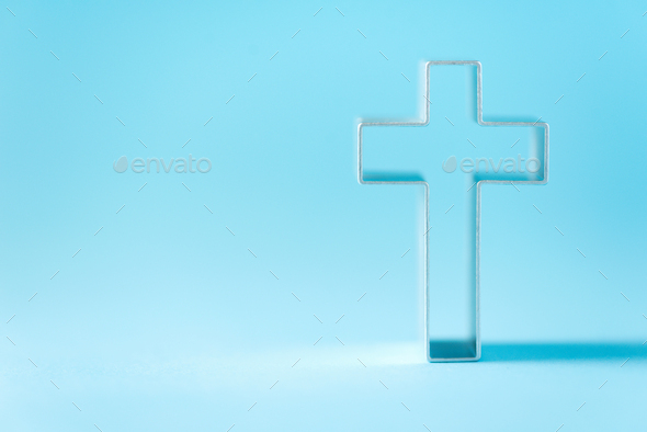 Christian cross on blue background with soft bokeh lights background. Copy space. Banner. Church