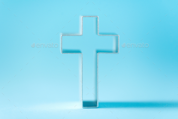 Christian cross on blue background with soft bokeh lights background. Copy space. Banner. Church
