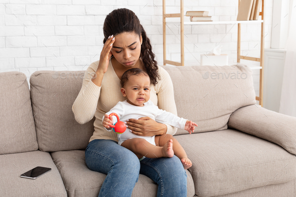 Black Mom Having Headache Sitting With Crying Baby At Home