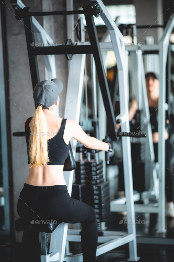 Athletic girl working out in gym. Sexy fitness woman doing exercise, flat  belly Stock Photo by ckstockphoto