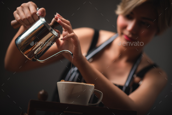 Professional barista preparing coffee using chemex pour over coffee maker  and drip kettle. Young woman making coffee. Alternative ways of brewing  coffee. Coffee shop concept. Stock Photo