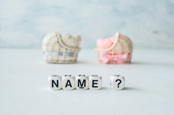 Concept of choosing baby name. Pink and blue decorative straw cradles with thread hearts and text - Stock Photo - Images