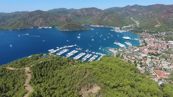 Small City Houses, Beautiful Marina and Touristic Boats in a Cove Surrounded by Forest by Sea alt