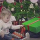 Happy Mom Dad and Cute Little Daughter Unwrap Christmas Gifts - VideoHive Item for Sale