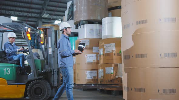 engineer staff male warehouse worker in hard hat working. walking through logistics center warehouse alt