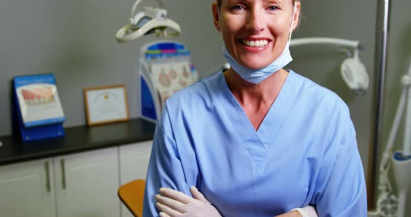 Dental assistant standing with arm crossed in clinic alt