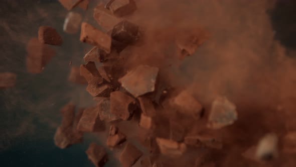 Super Slow Motion Shot of Raw Chocolate Chunks and Cocoa Powder After Being Exploded at 1000 Fps. alt