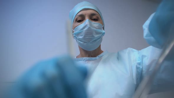 Professional Female Surgeon Conducting Surgery in Operating Room, Medicine