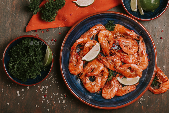 Large plate with grilled shrimps. Seafood dinner Stock Photo by OksaLy