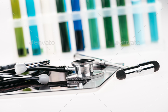 close up view of stethoscope on digital tablet and reflex hammer on white