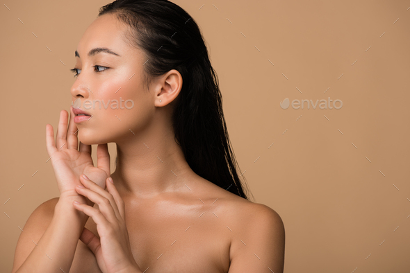 590px x 394px - beautiful naked asian girl looking away and touching face isolated on beige  Stock Photo by LightFieldStudios