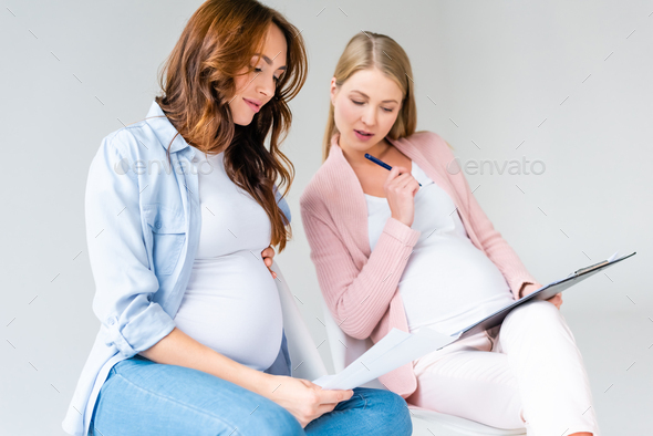 pregnant women talking during antenatal class isolated on grey