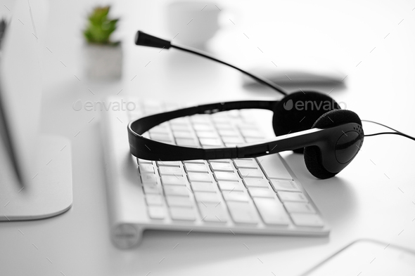 Headset and keyboard on the desk in the office - Stock Photo - Images