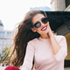 Closeup portrait of attractive girl in sunglasses with vinous lips in the city. Her long hair is fly - PhotoDune Item for Sale
