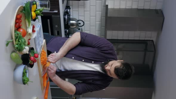 Vertical Shot of Male Chef Cutting Vegetables and Cooking in the Kitchen, Slow Motion alt