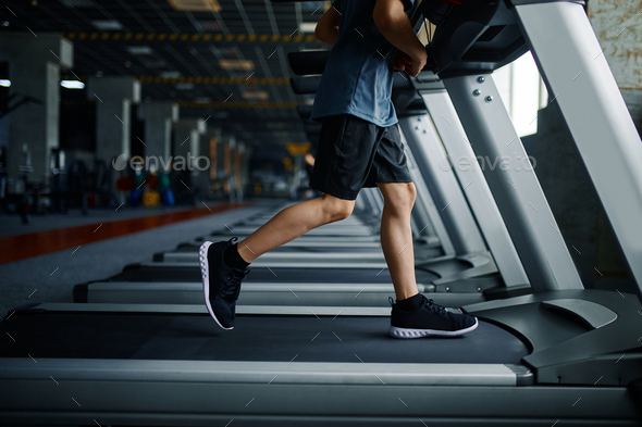 Youngster doing exercise on treadmill in gym - Stock Photo - Images