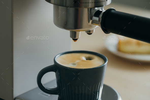 Morning ritual at breakfast with pouring coffee from coffee machine, drops of espresso dripping - Stock Photo - Images
