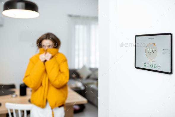 Smart home digital panel with heating app and woman feeling cold