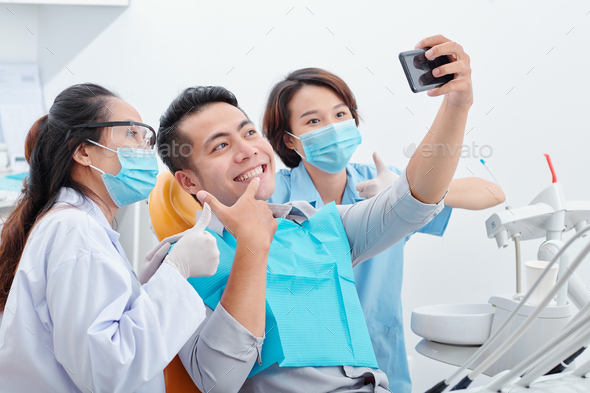 Man taking selfie with dentist and assistant