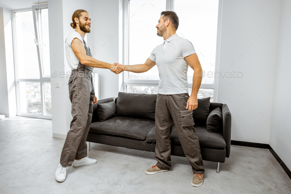 Workers shaking hands in the apartment