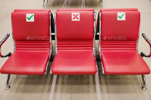 Row of three empty red leather seats inside lounge of large contemporary airport where you can relax - Stock Photo - Images