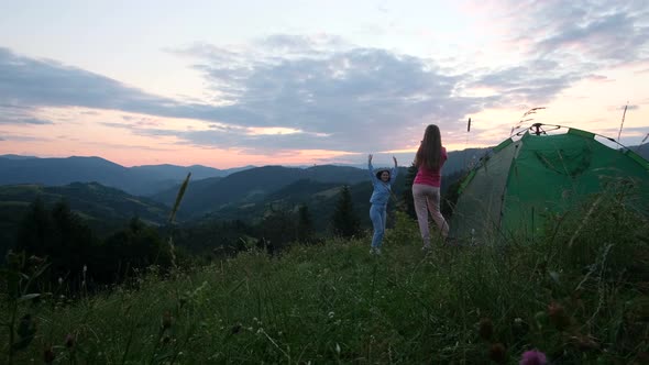 Two Girls are Photographed in the Mountains at Sunset alt