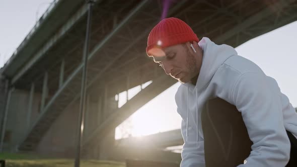 Young Man Tying His Shoelaces Before Starting Daily Routine Workout. Man Doing Exercises and Warm Up