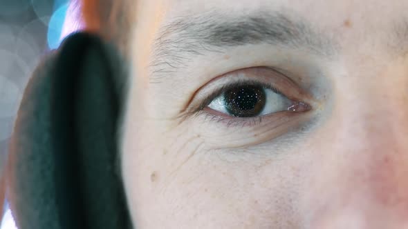 Close-up of Man Eye, in the Pupil the Reflection of Garlands and New Year's Lights. alt