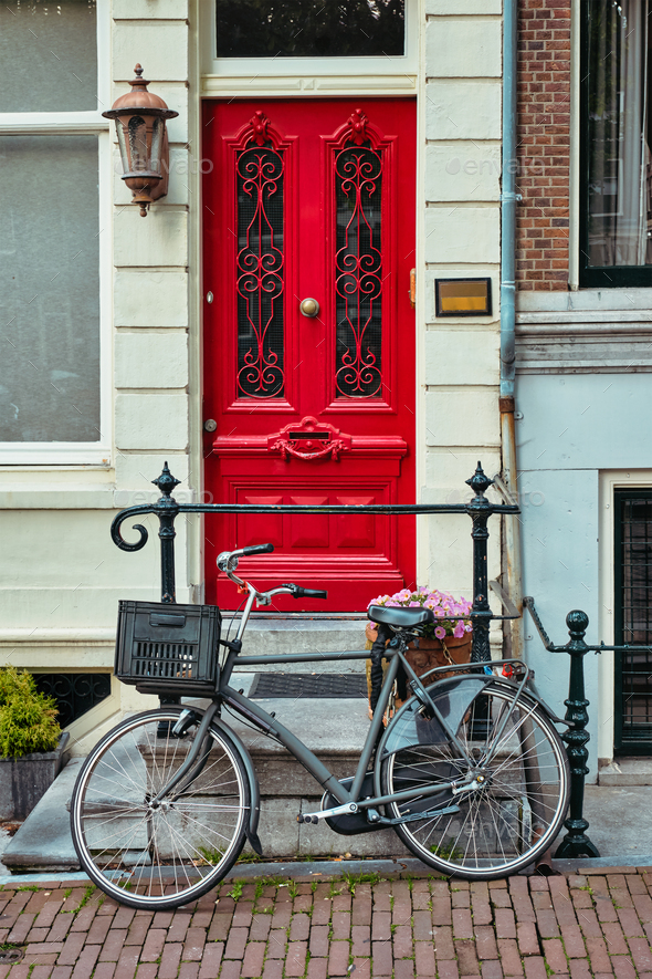 Bicycle near door of old house in Amsterdam street - Stock Photo - Images