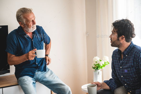 The elderly father and middle-aged son Talking in the house With a coffee cup in hand