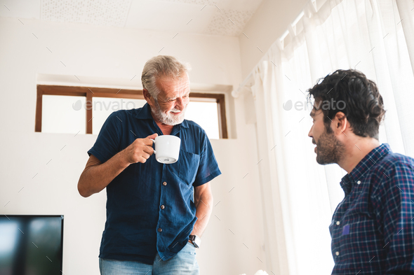 The elderly father and middle-aged son Talking in the house With a coffee cup in hand