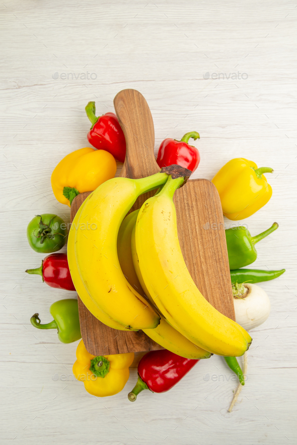 top view fresh bell-peppers with bananas on white background diet salad healthy life photo ripe