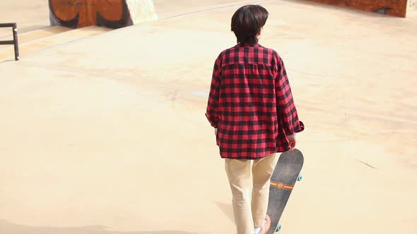 Teenage Girl Learning to Ride Skateboard in a Skatepark