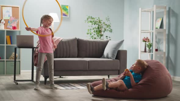 Blond Hair Children Relaxing in Bright Room Smiling Girl is Spinning Hula Hoop alt
