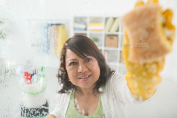 Housewife cleaning table Stock Photo by DragonImages